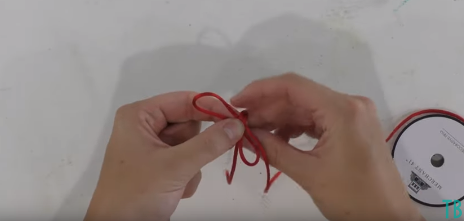 Fold One Loop Over The Other And Through The Middle To Make Your Bow