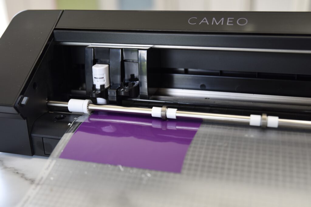 Displaying a Silhouette Cameo machine showing how to line up mat as it's loaded