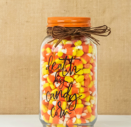 Jar of candy corn with text on it saying death by candy corn
