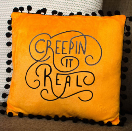 Halloween Throw Pillow - orange with black pompom trim and black lettering saying Creepin it Real