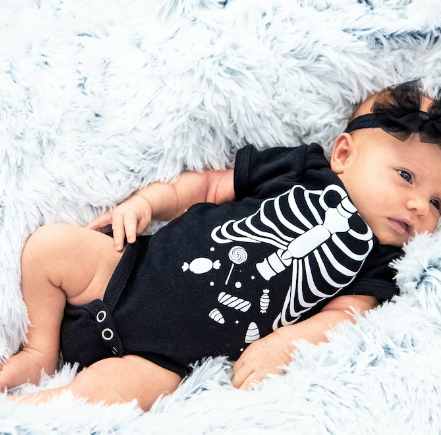 Skeleton Onesie - black baby onesie with white skeleton design on it showing candy in the stomach area