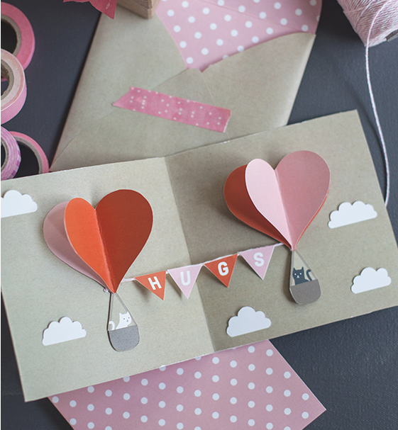 heart shaped hot air balloons with cats in the baskets pop up card with text on bunting saying hugs. 