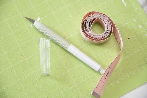 Cricut TrueControl Knife with a measuring tape on a cutting mat