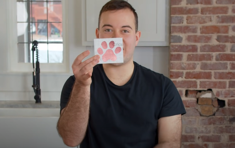 Man Holding Up A Paw Print Vinyl Decal