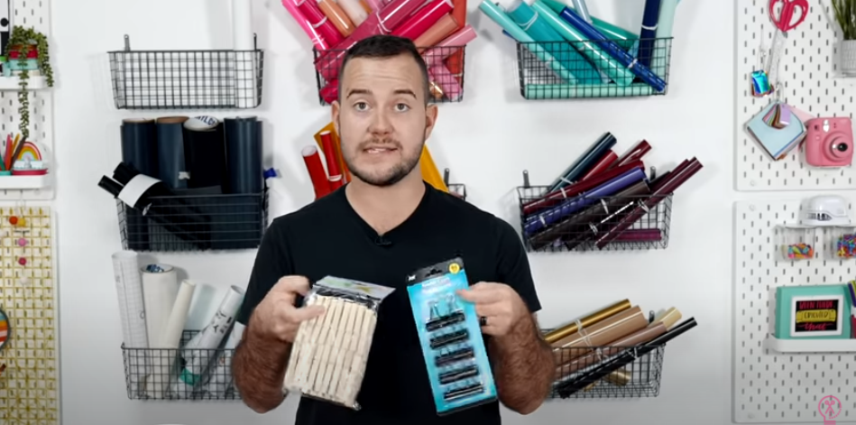 Man Holding A Package Of Binder Clips And One Of Wooden Clothes Pins